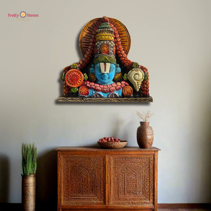 Decorative wall piece with colorful design above a wooden cabinet.