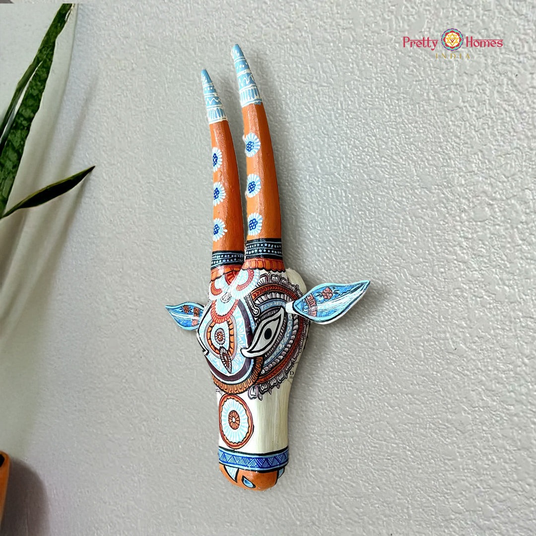 wood-carved orange and blue nandi cow head wall decor, hand-painted with bold hues and detailed carving