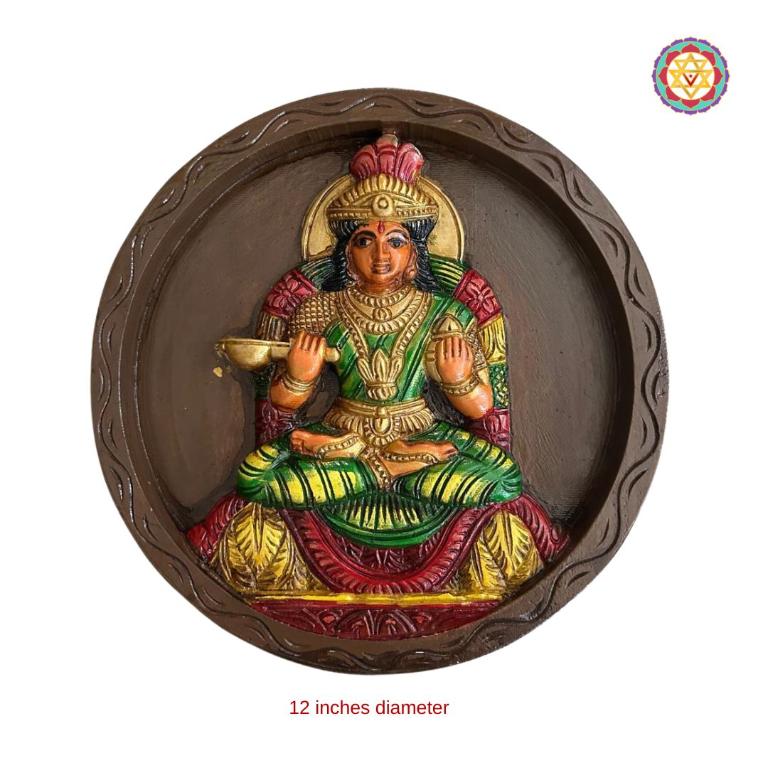 close-up of annapurna devi carved face and ornate circular frame in teakwood finish
