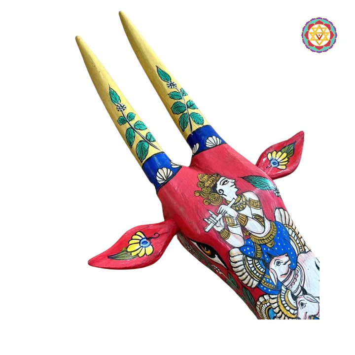 angled view of red Krishna cow head showing painted crown and ornamental motifs