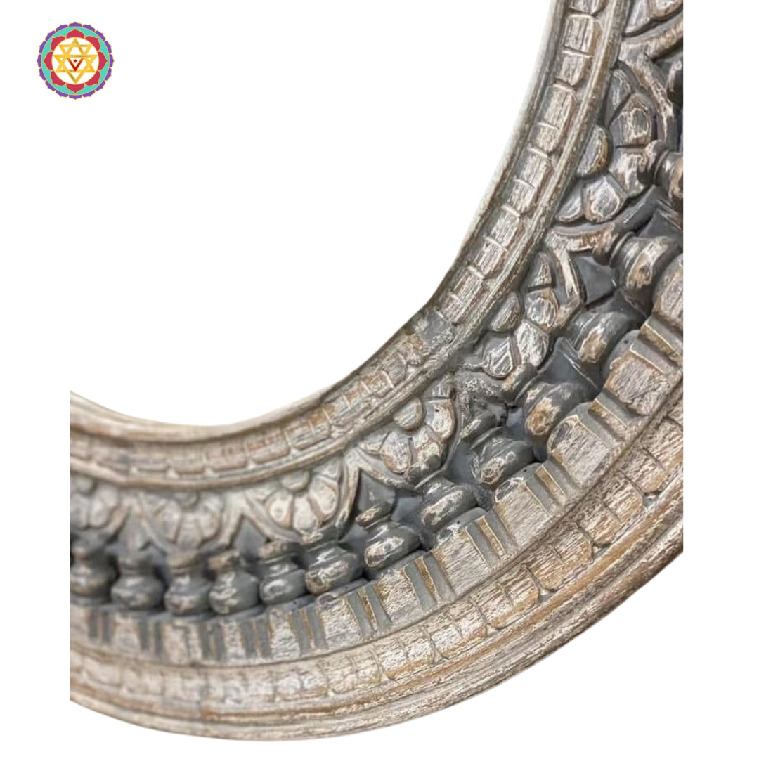 Close-up of ornate distressed carving on mirror edge
