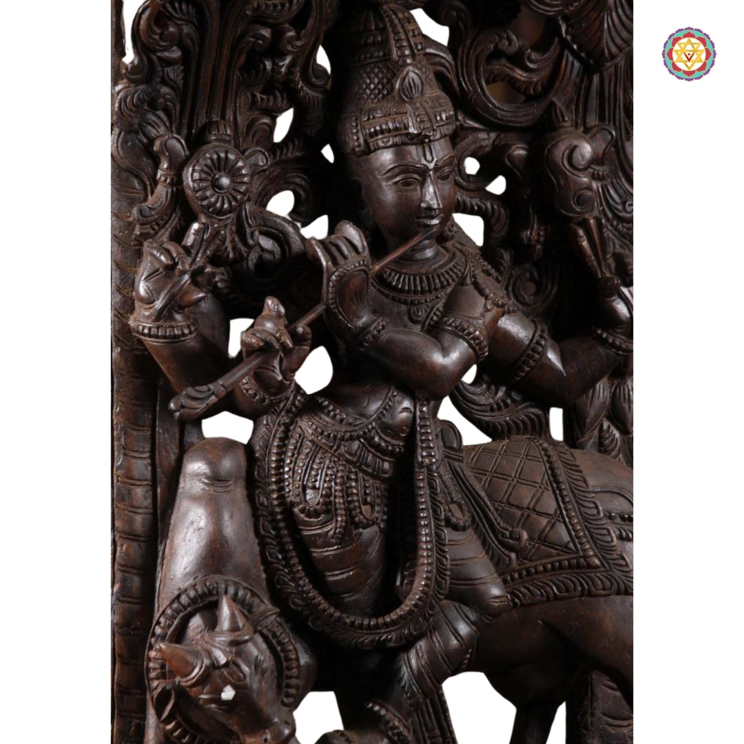 Side angle of carved Krishna panel showing detailed canopy and posture