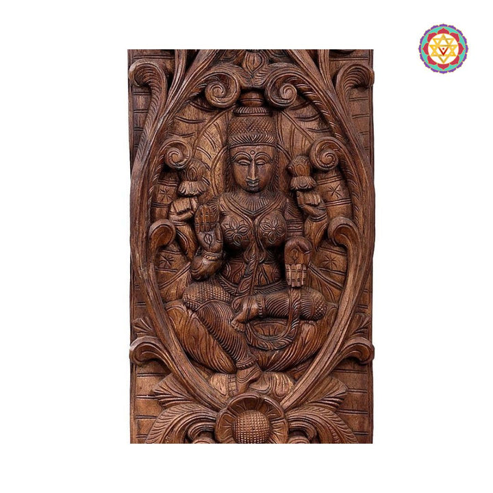Wooden carvings of a seated figure with intricate designs on a white background - Close-up of Lakshmi carving with lotuses and Yalis