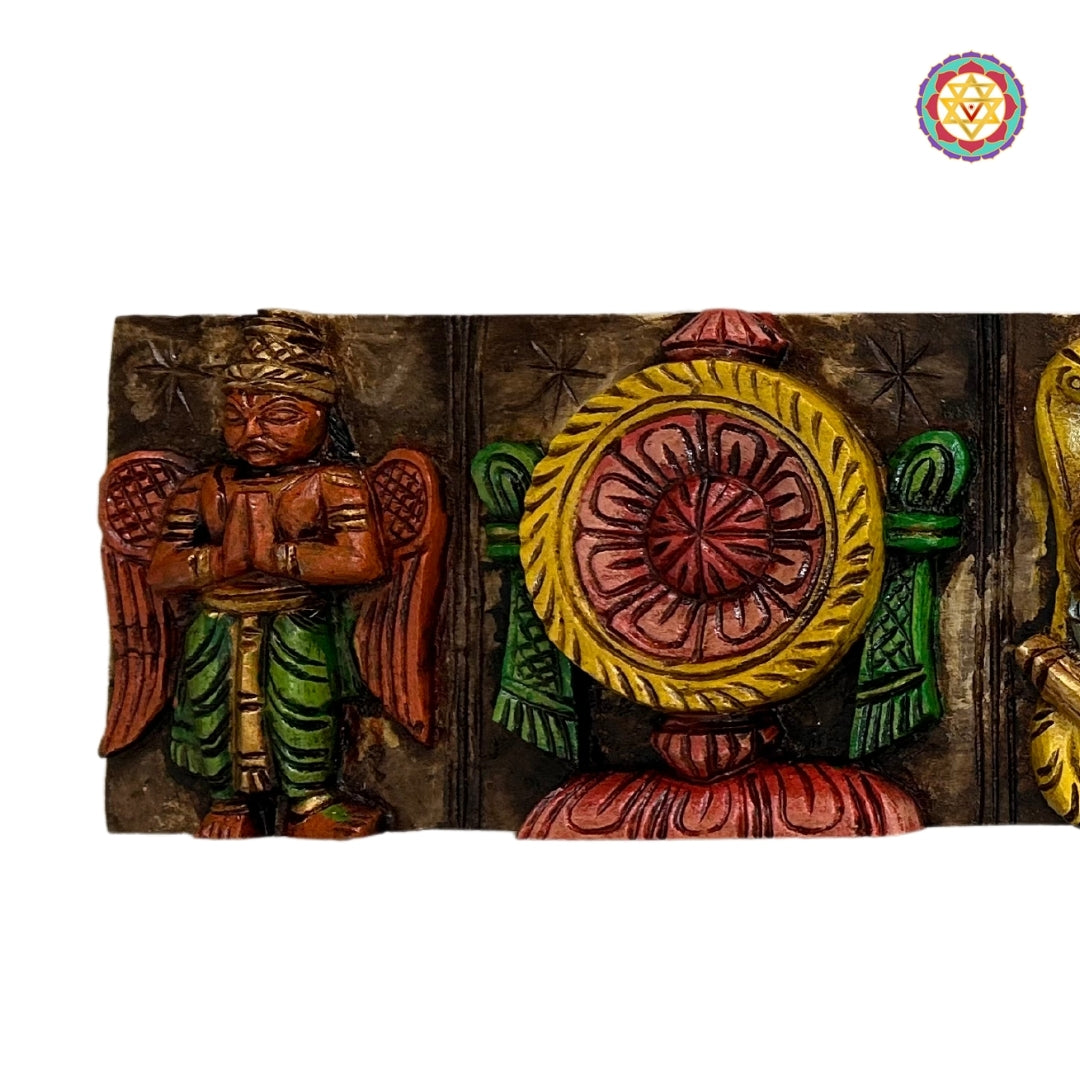 Close-up of carved wooden wall panels featuring Lord Balaji symbols