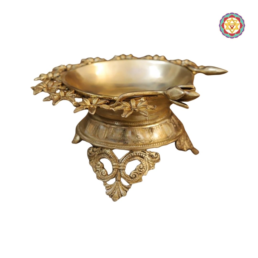 side-angle view of brass flower urli highlighting petal-shaped rim