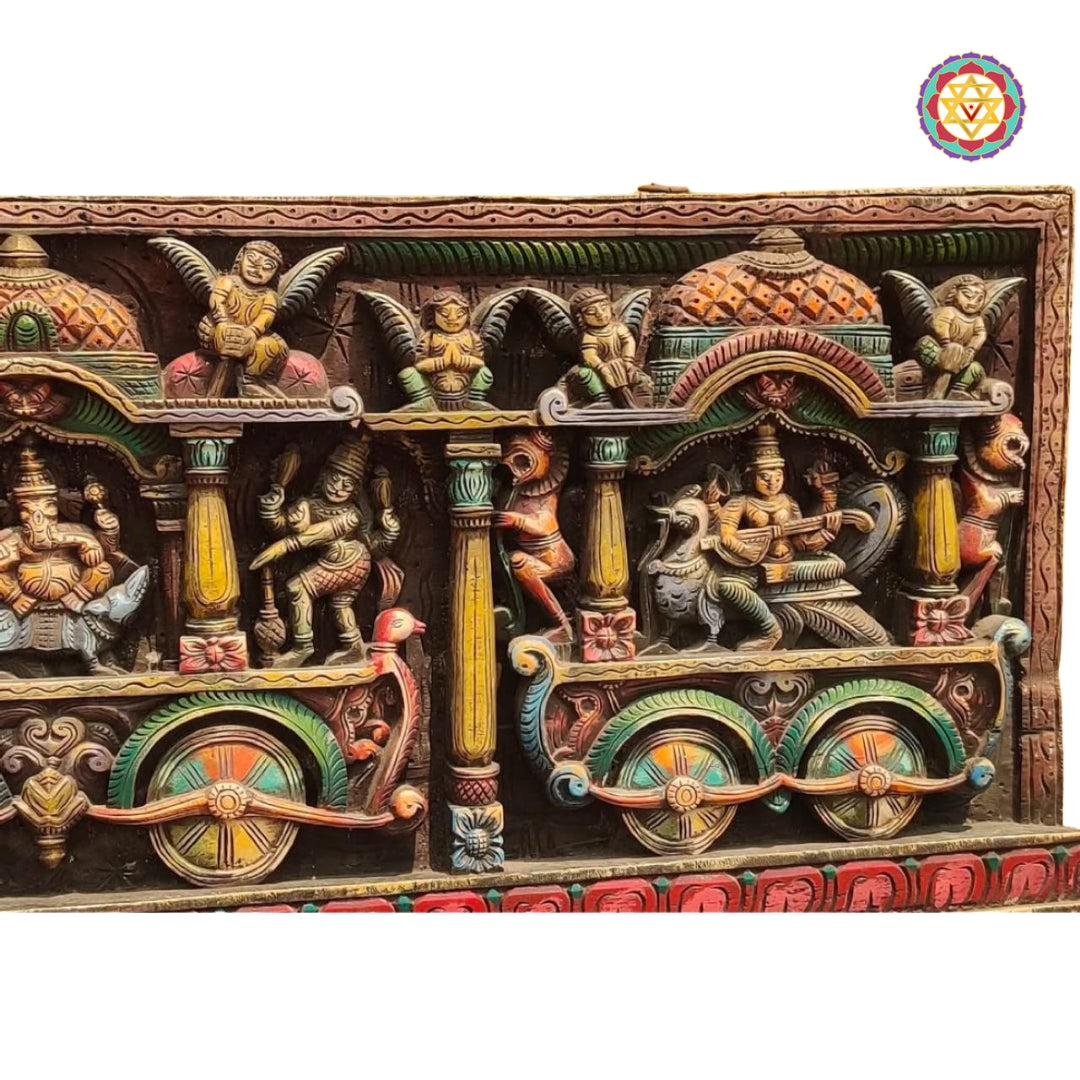 Lord Ganesh carved in vivid tones with ornate chariot wheel design