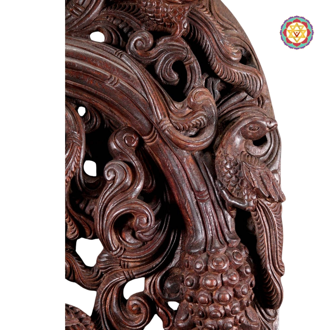 Close-up of carved canopy showing floral and vine details above Lord Krishna statue