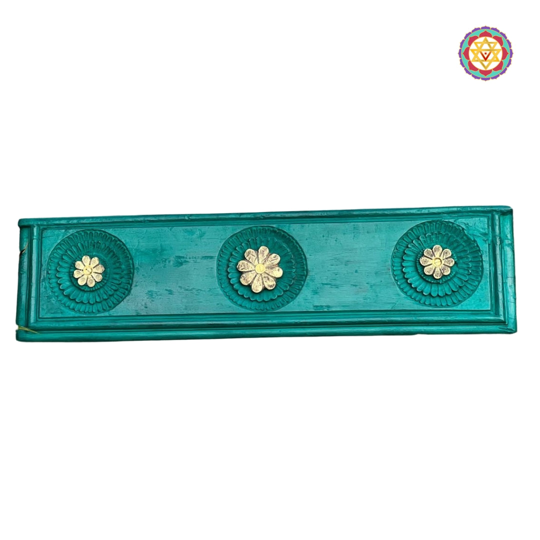 Horizontal view showing three brass flower carvings