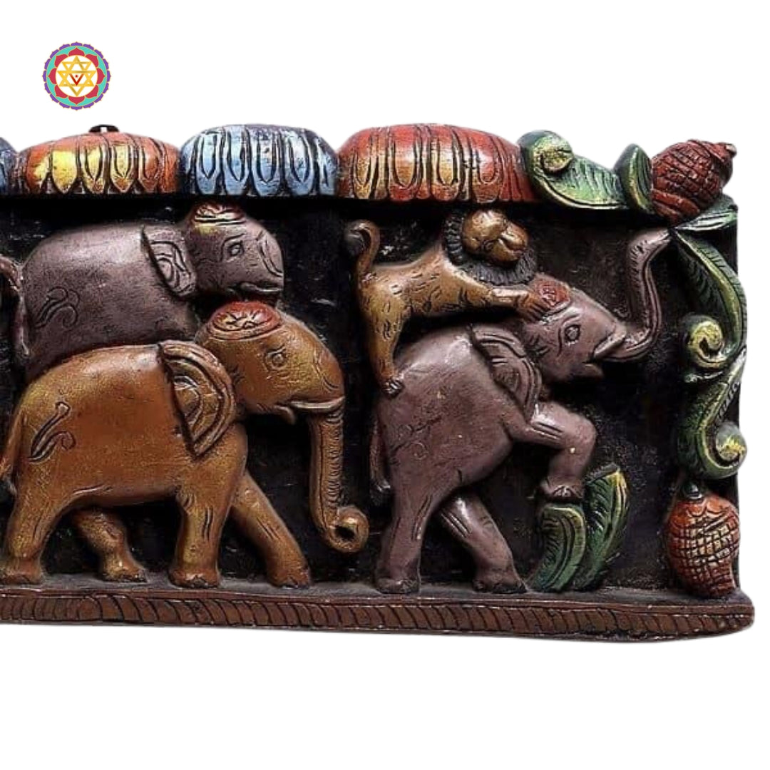 Side profile of carved elephants in wooden frame