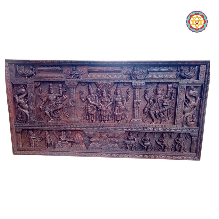 Wooden panel with intricate carvings of deities on a white background - Side view of handcarved Shiva-Parvati wedding panel