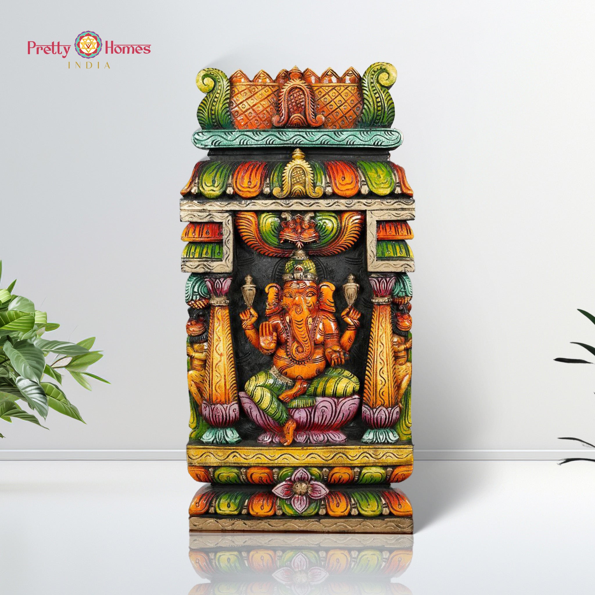 Hand-carved wooden wall mount featuring the figure of Ganesha with multicolored detailing, in a style reminiscent of a temple gopuram.