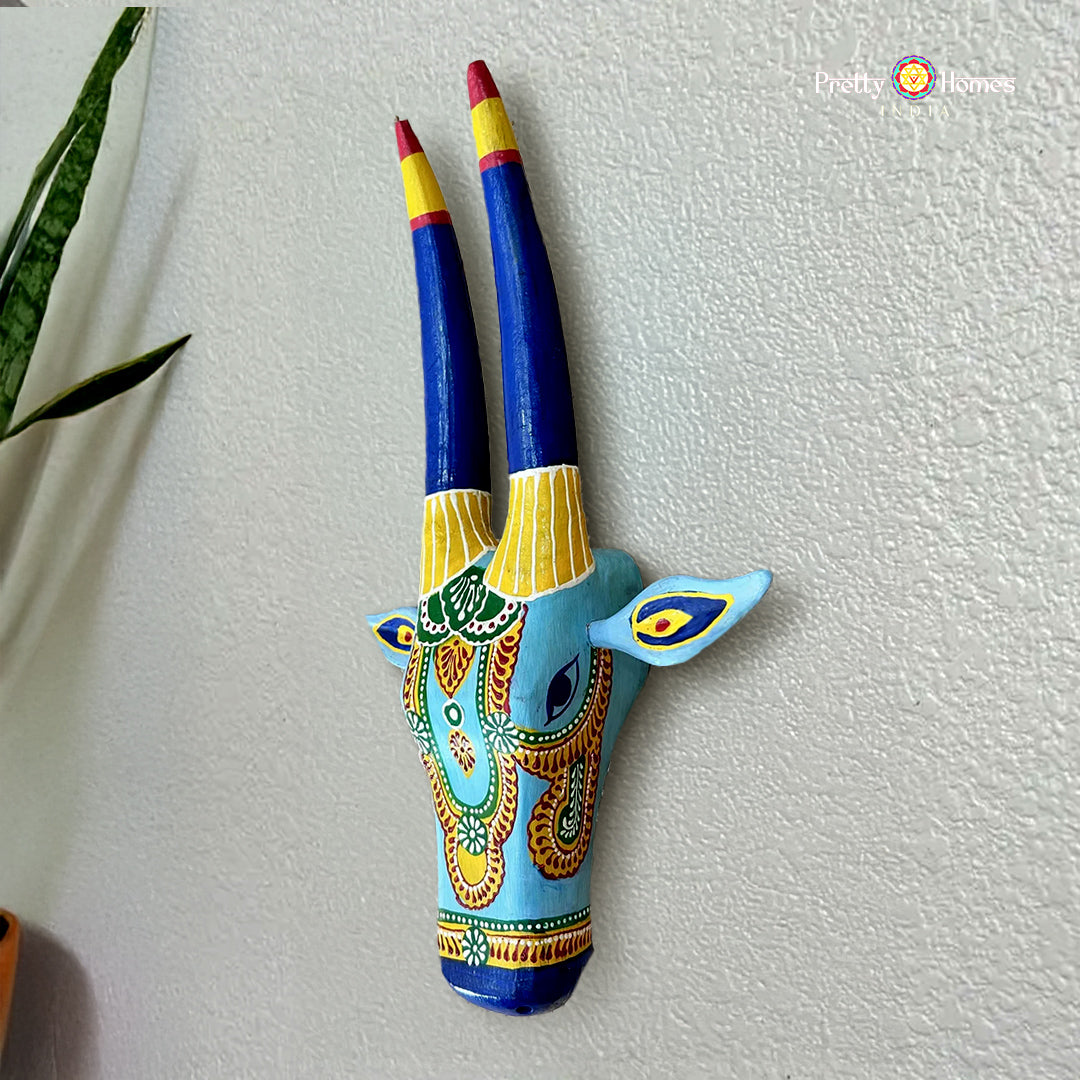 wood-carved blue and yellow nandi cow head wall decor, vibrant hand-painted detailing and carved horns
