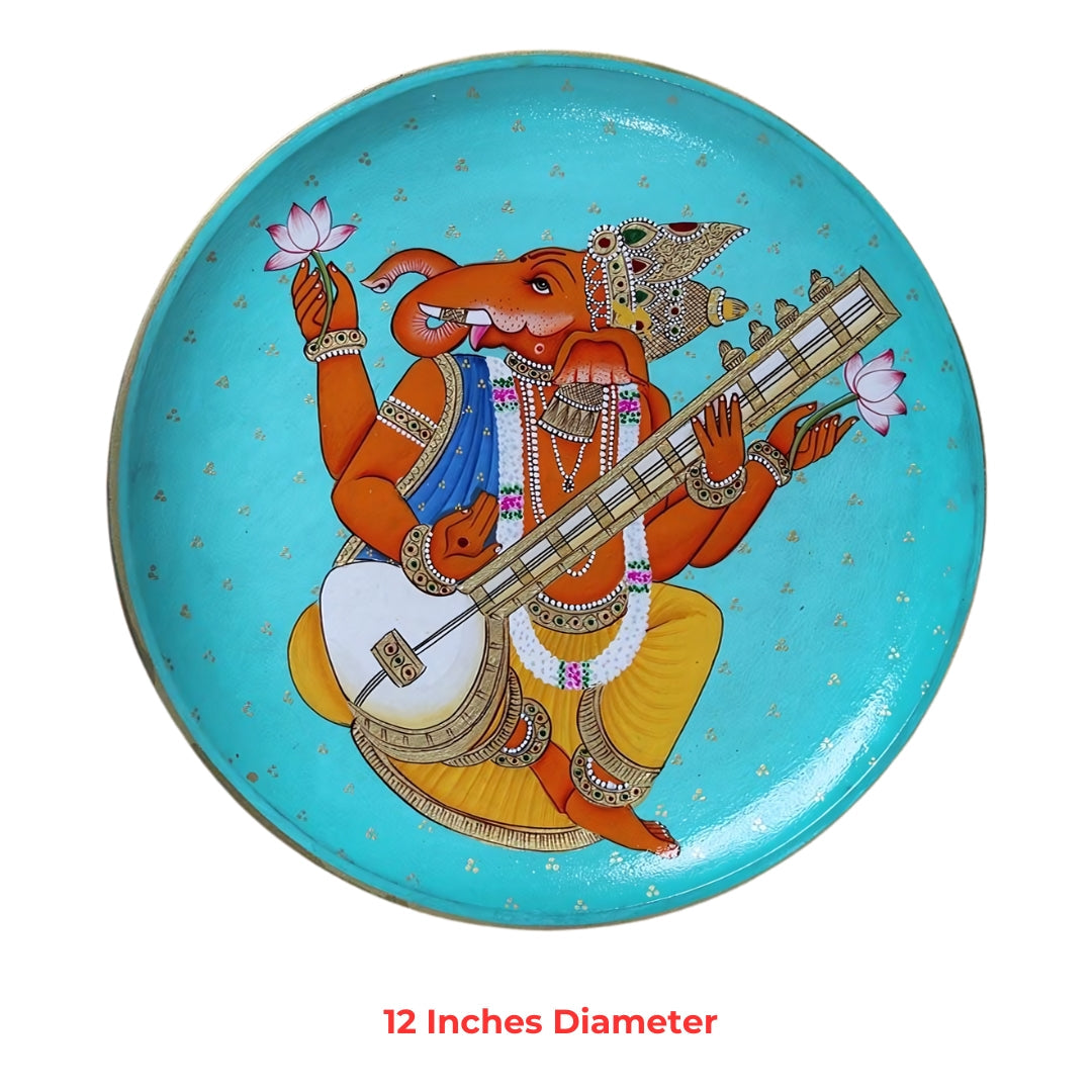 Hand-painted round plate showing Lord Ganesha playing veena on turquoise background