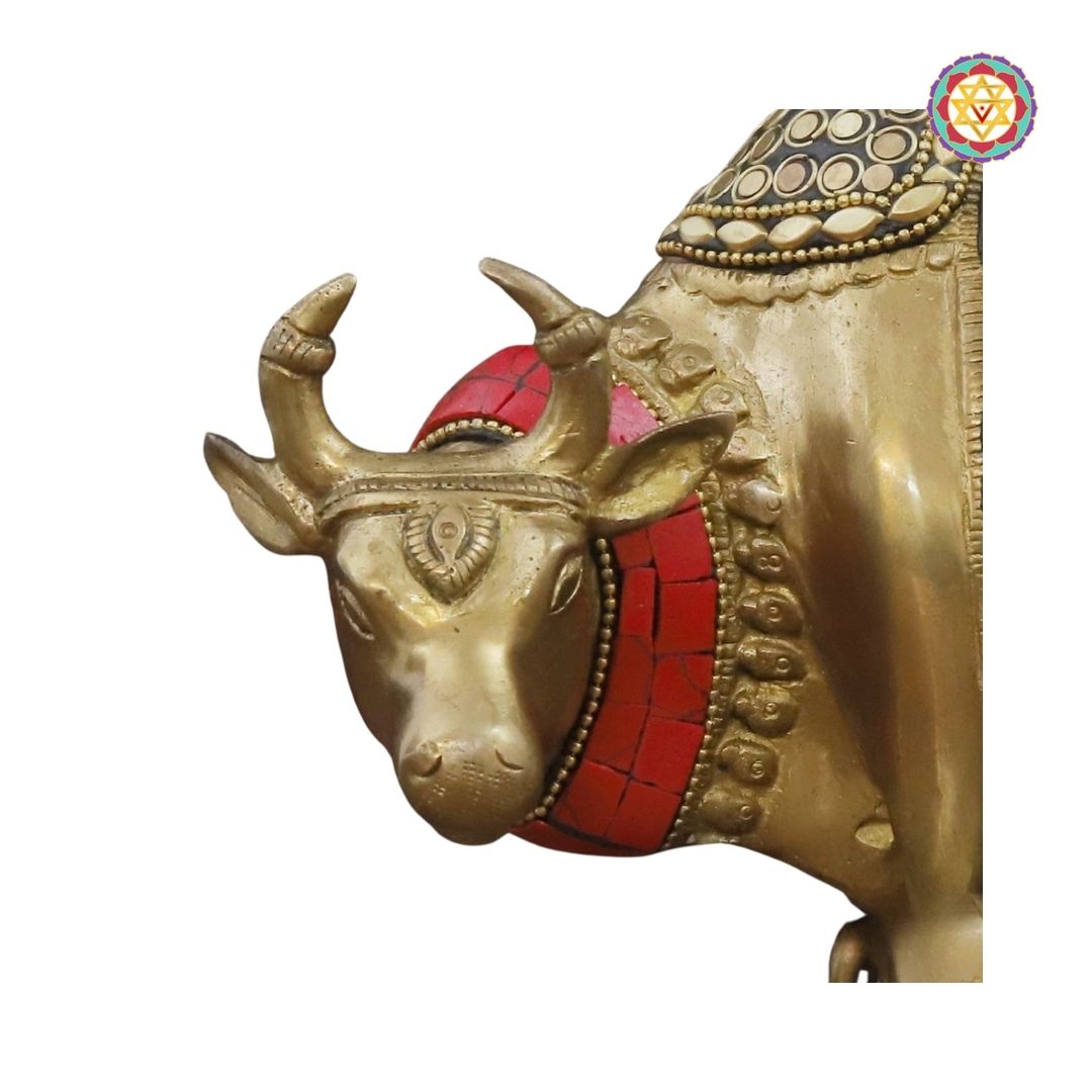 side-angle view of brass Kamdhenu statue showing decorative carvings