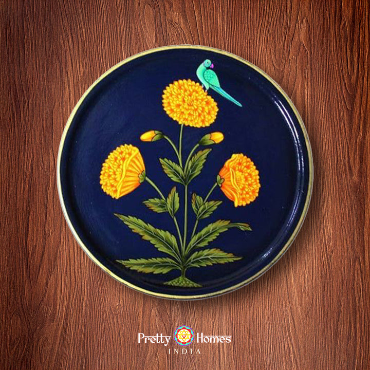 Close-up of marigold floral pichwai design on a round wall plate.