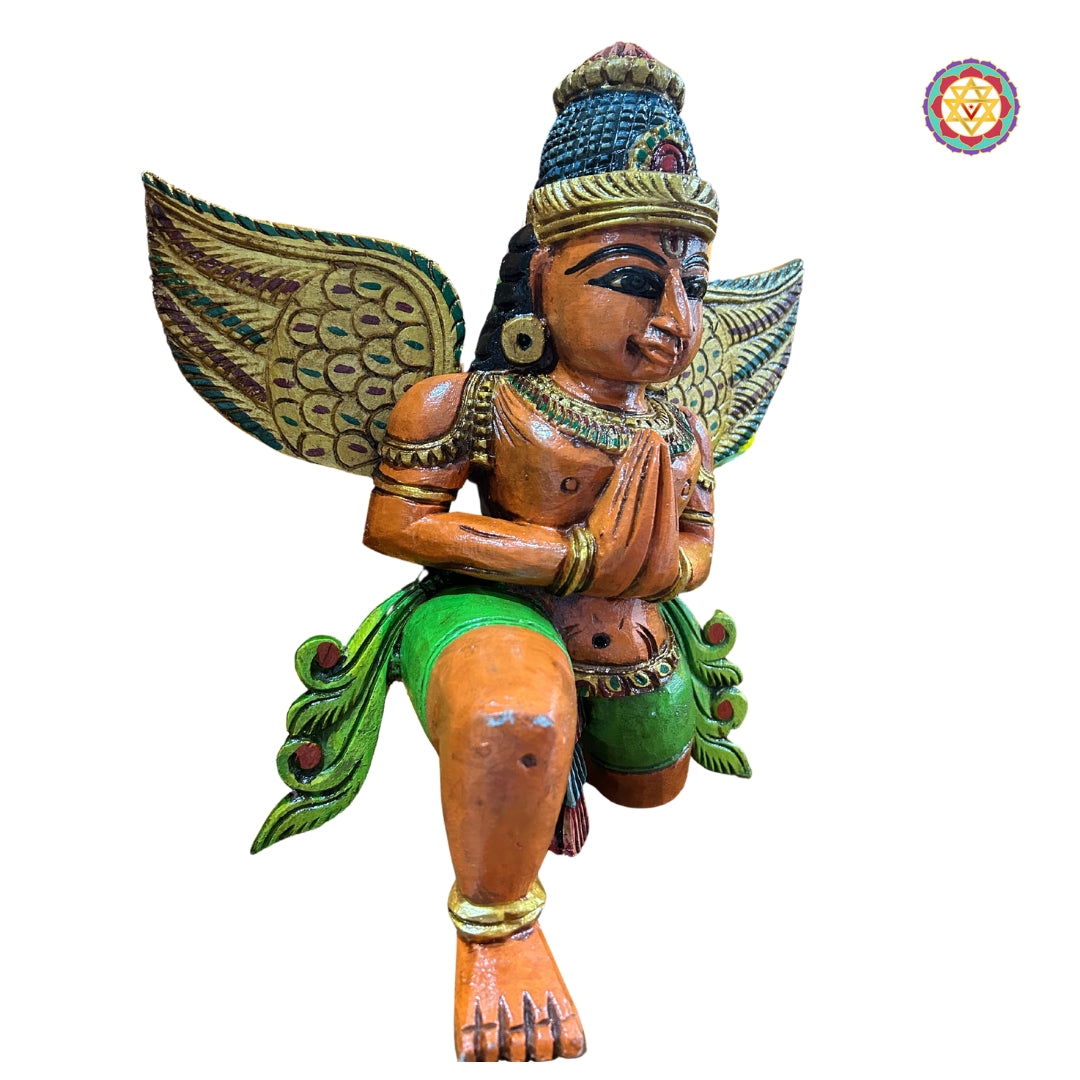 Close-up of Garuda sculpture face and chest carving — hand-painted wooden religious art with feather details