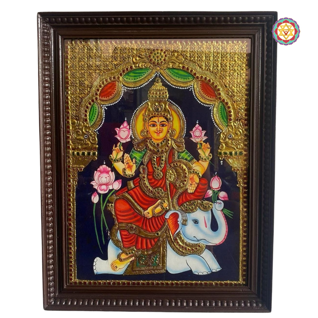 Side view of gold foil Gajalakshmi painting in carved teakwood frame