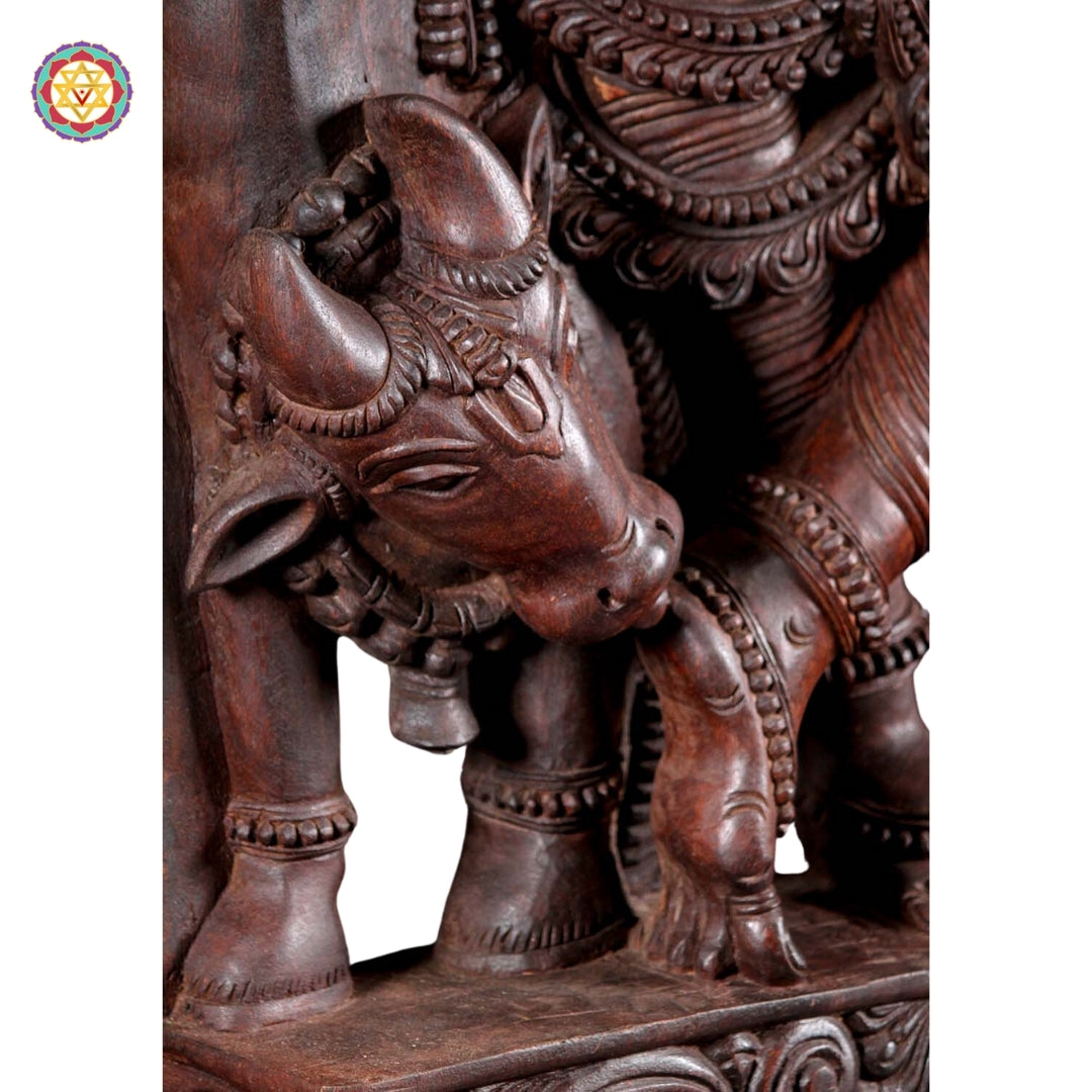 Angled view of Krishna wood sculpture showing divine flute pose and detailed canopy carvings