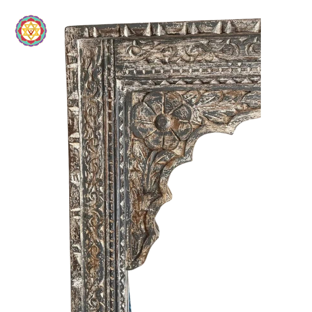 Close-up of the handcarved floral and geometric latticework on the wooden jharokha mirror frame.
