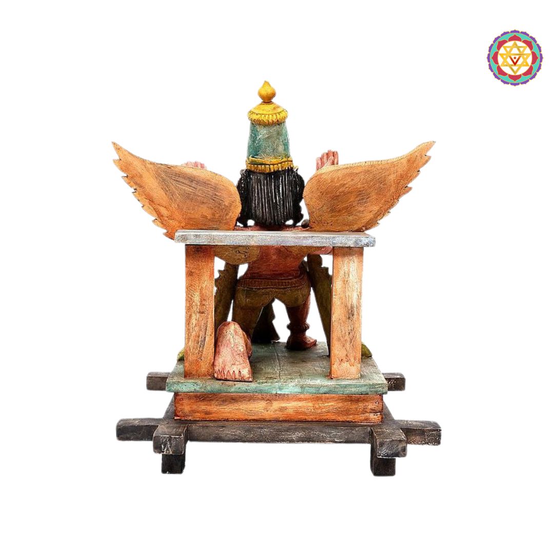 side view of detailed garuda carving on wooden base