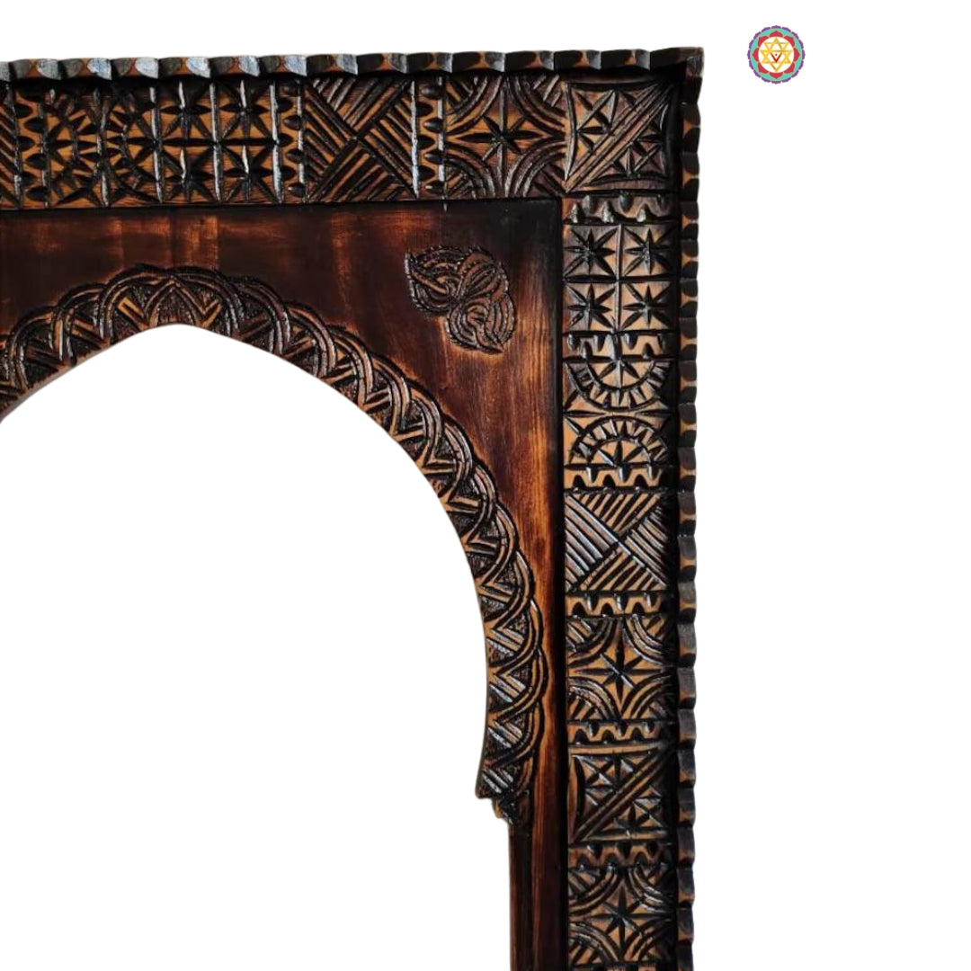 Arched detail of dark brown carved wooden mirror frame
