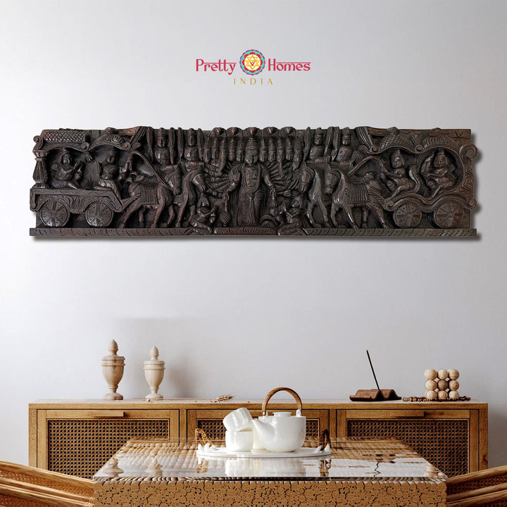 Decorative wall art with intricate carvings above a wooden cabinet with tea set.