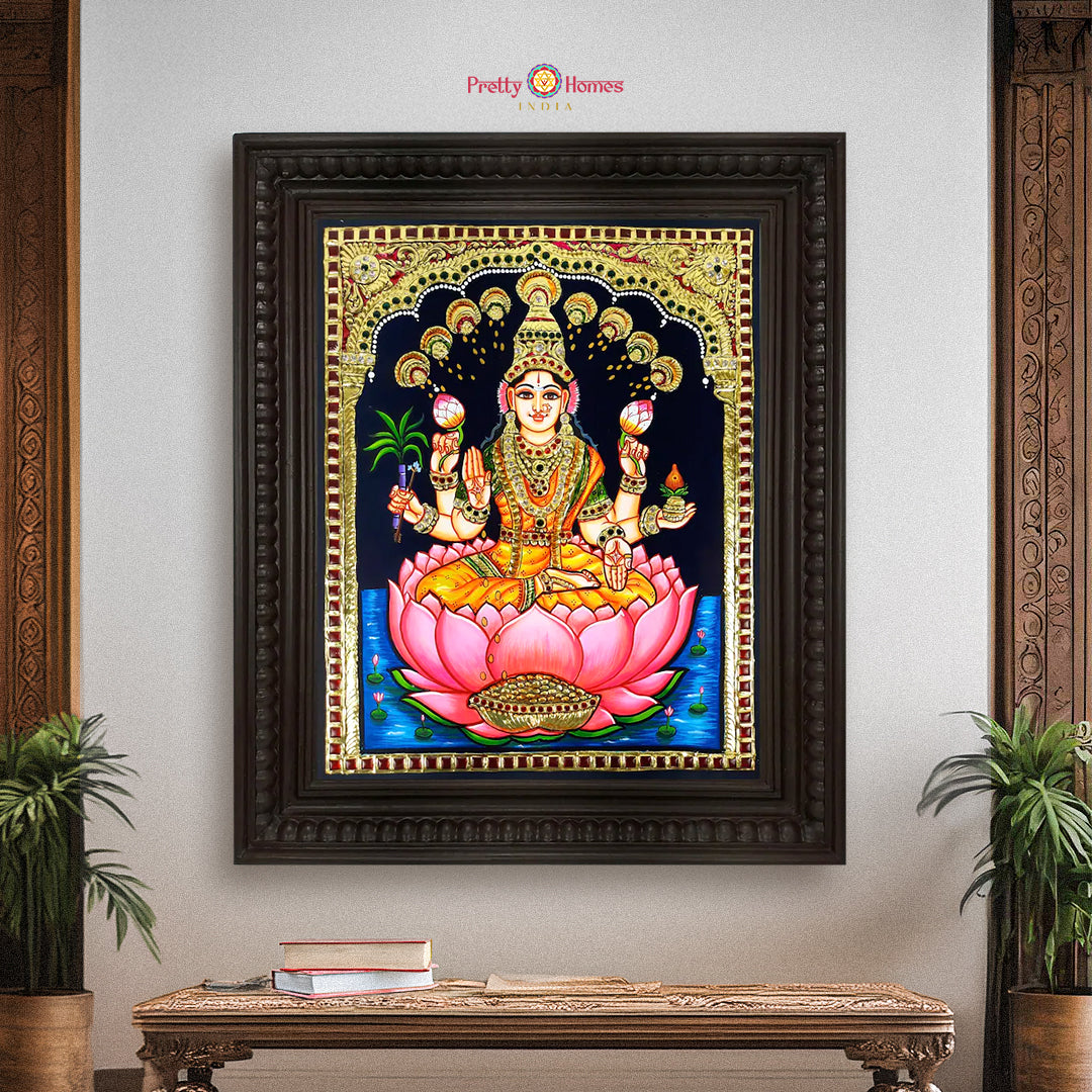 “Framed Lakshmi Tanjore painting in 22-carat gold foil displayed on interior wall with lotus throne”