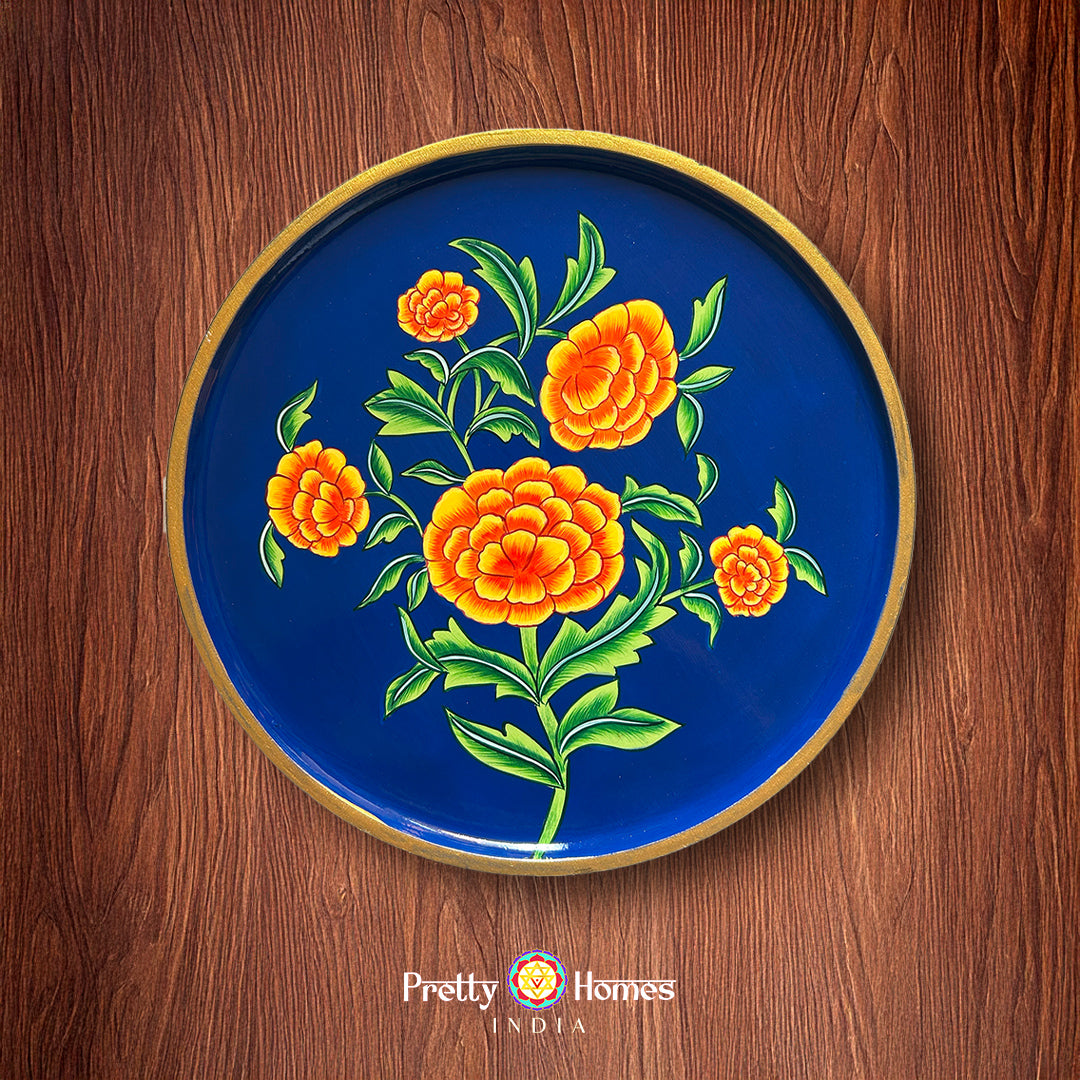 Handpainted wall plate with orange marigold blossoms in pichwai style.