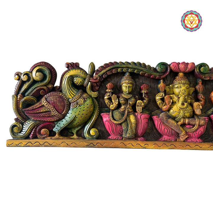 Decorative wall art with colorful figures on a white background: Close-up of Annam bird carvings and divine trio on wooden wall panel

