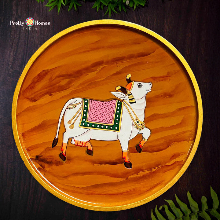 Hand-painted Pichwai cow wall plate with rich wooden finish and traditional heritage artwork
