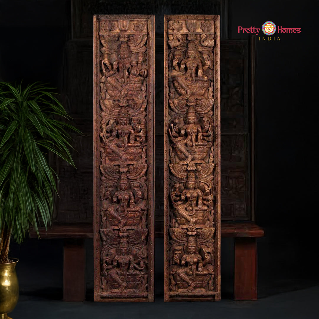 A pair of large, vertical wooden panels with intricate carvings depicting Hindu goddess Ashtalakshmi in various forms.