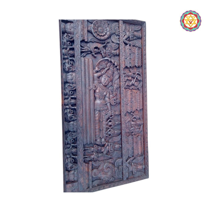 Wooden panel with intricate carvings on a white background. Large wooden wall panel with reclining Vishnu and celestial deities

