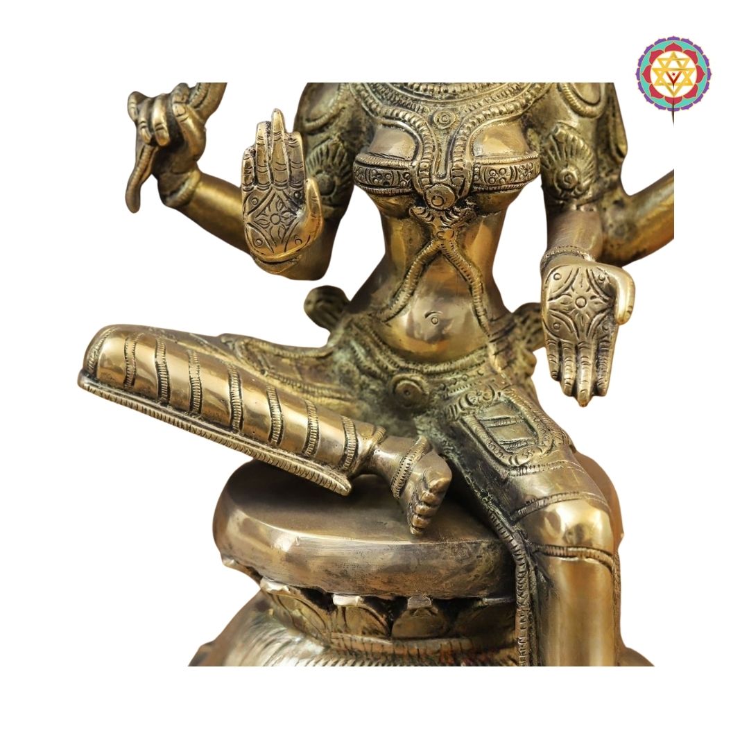 side view of Saraswati idol highlighting ornate attire and veena carving