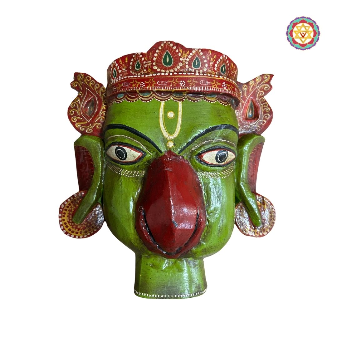 Close-up of Garuda wooden face mask sculpture on black metal stand