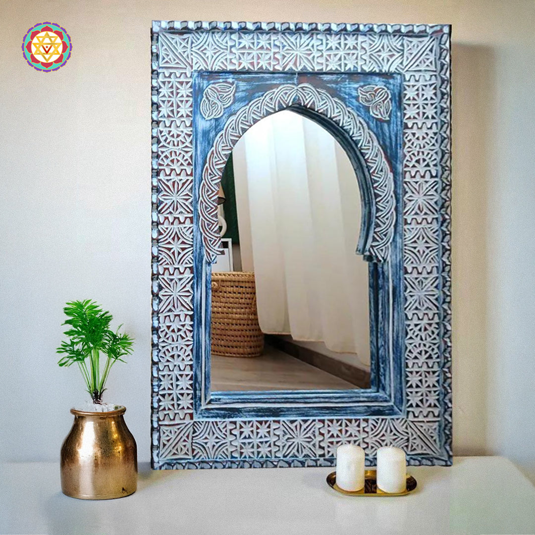 Blue vintage-style carved wood mirror frame with decor items