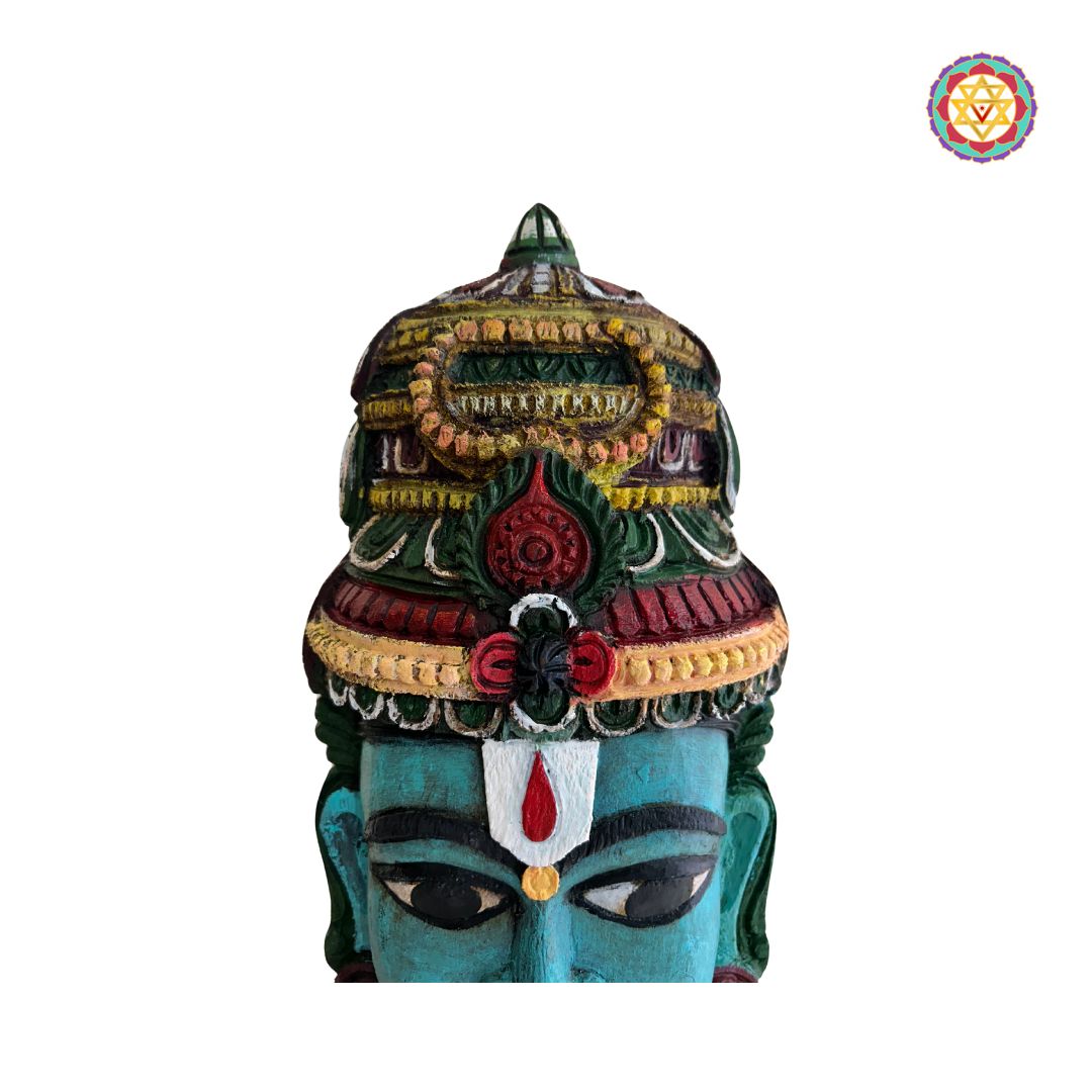 Close-up of table top wooden Vishnu face mask with vibrant colors