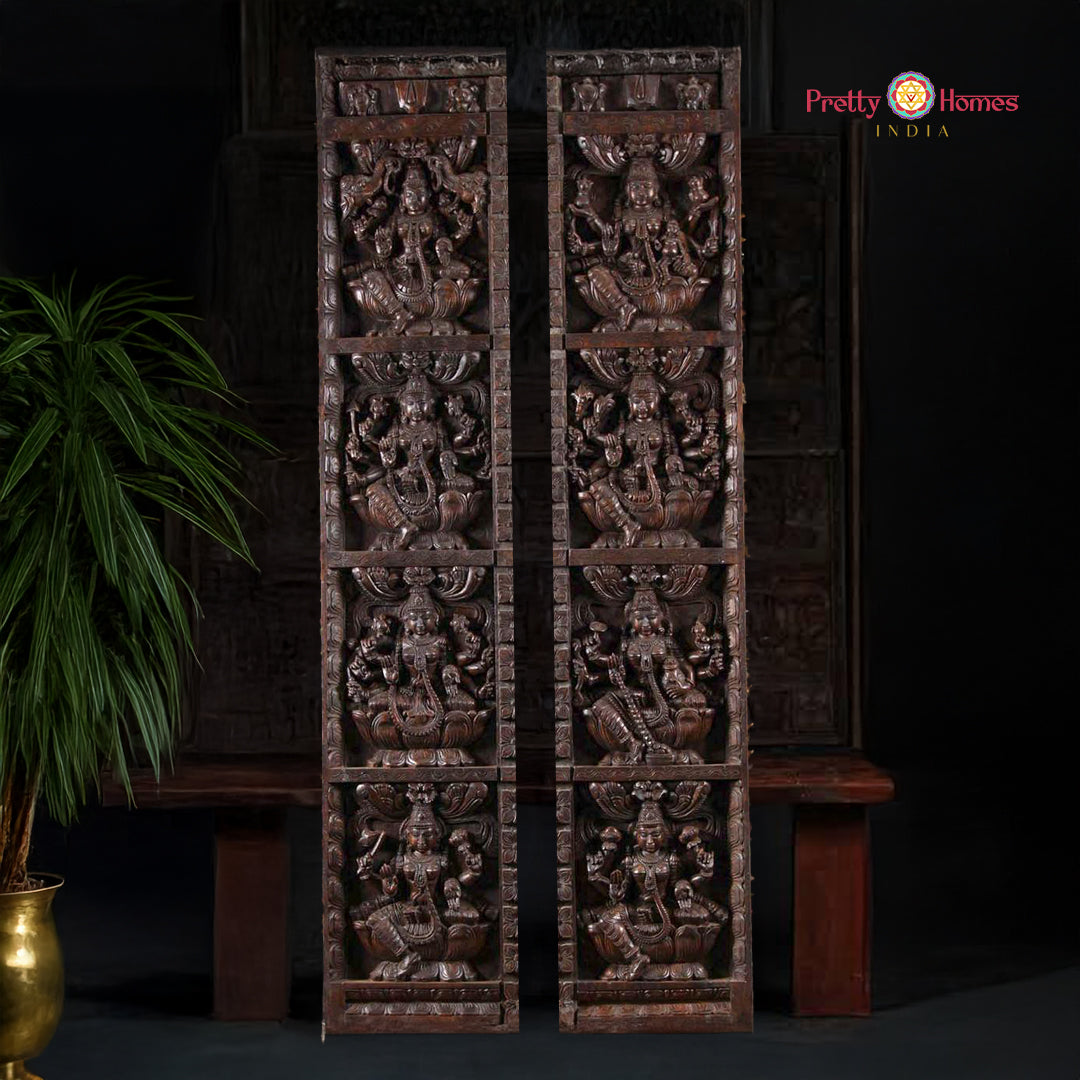 A pair of large, vertical, wooden wall panels with intricate carvings depicting Hindu deities.