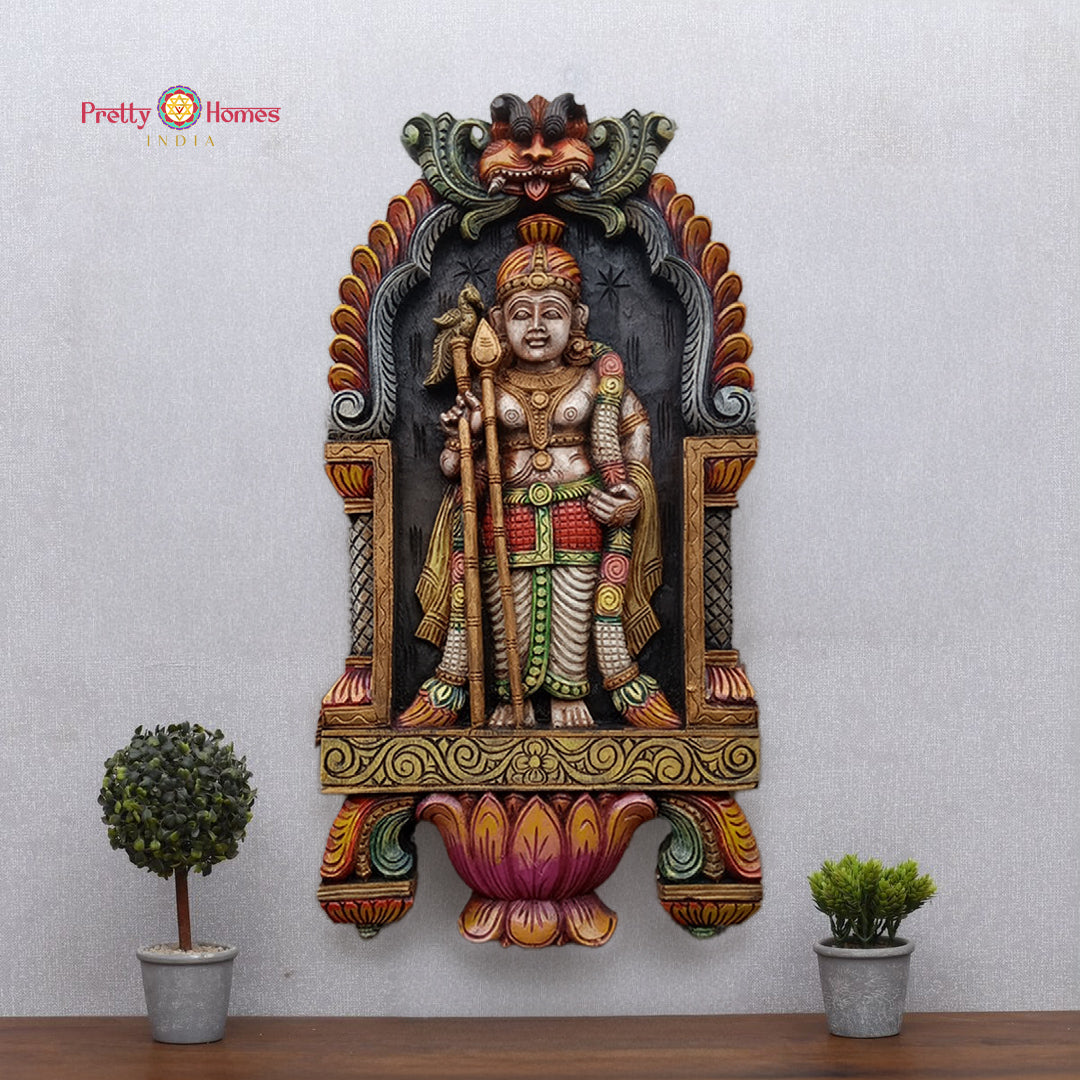 large handcarved standing murugan frame full view showing lotus and kirthimukha motifs with carved deity