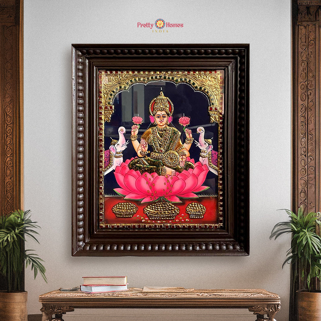 “Framed Gajalakshmi Tanjore painting with 22-carat gold foil, displayed on wall with traditional decor”