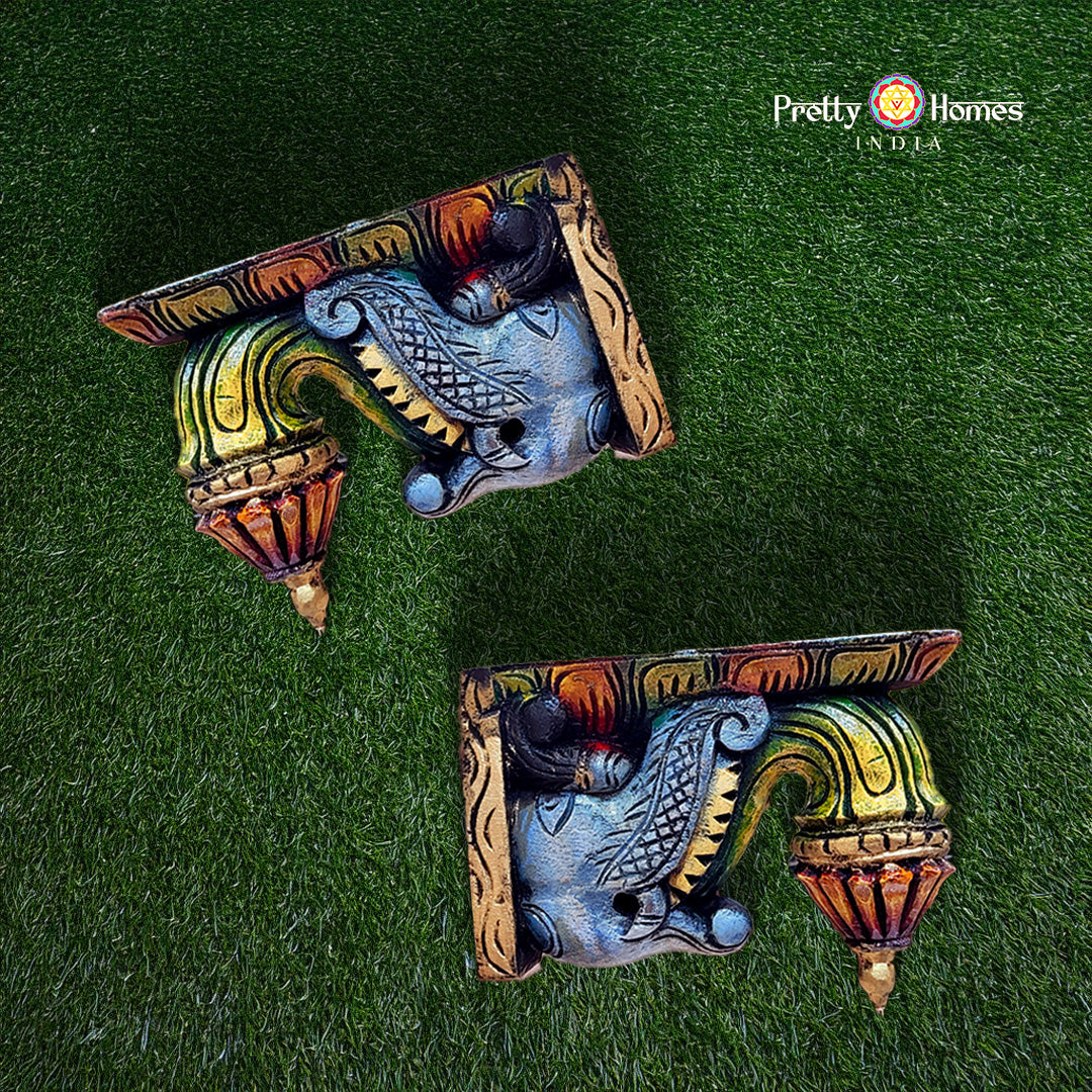 Decorative wall brackets with colorful design on a green background, branded 'Pretty Homes India'.