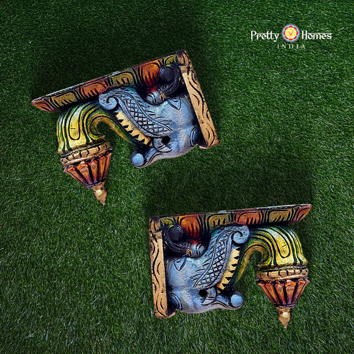 Decorative wall brackets with colorful design on a green background, branded 'Pretty Homes India'.