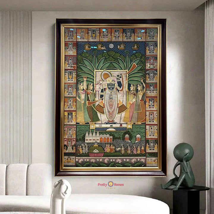 Framed traditional painting of deity with gopis and ornate border panels staged in modern interior