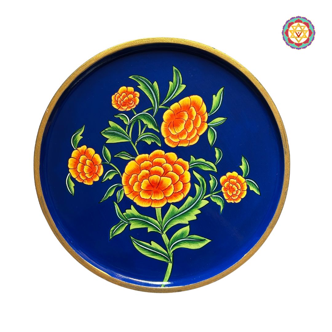 Decorative marigold floral wall plate in pichwai art style, on wooden backdrop.