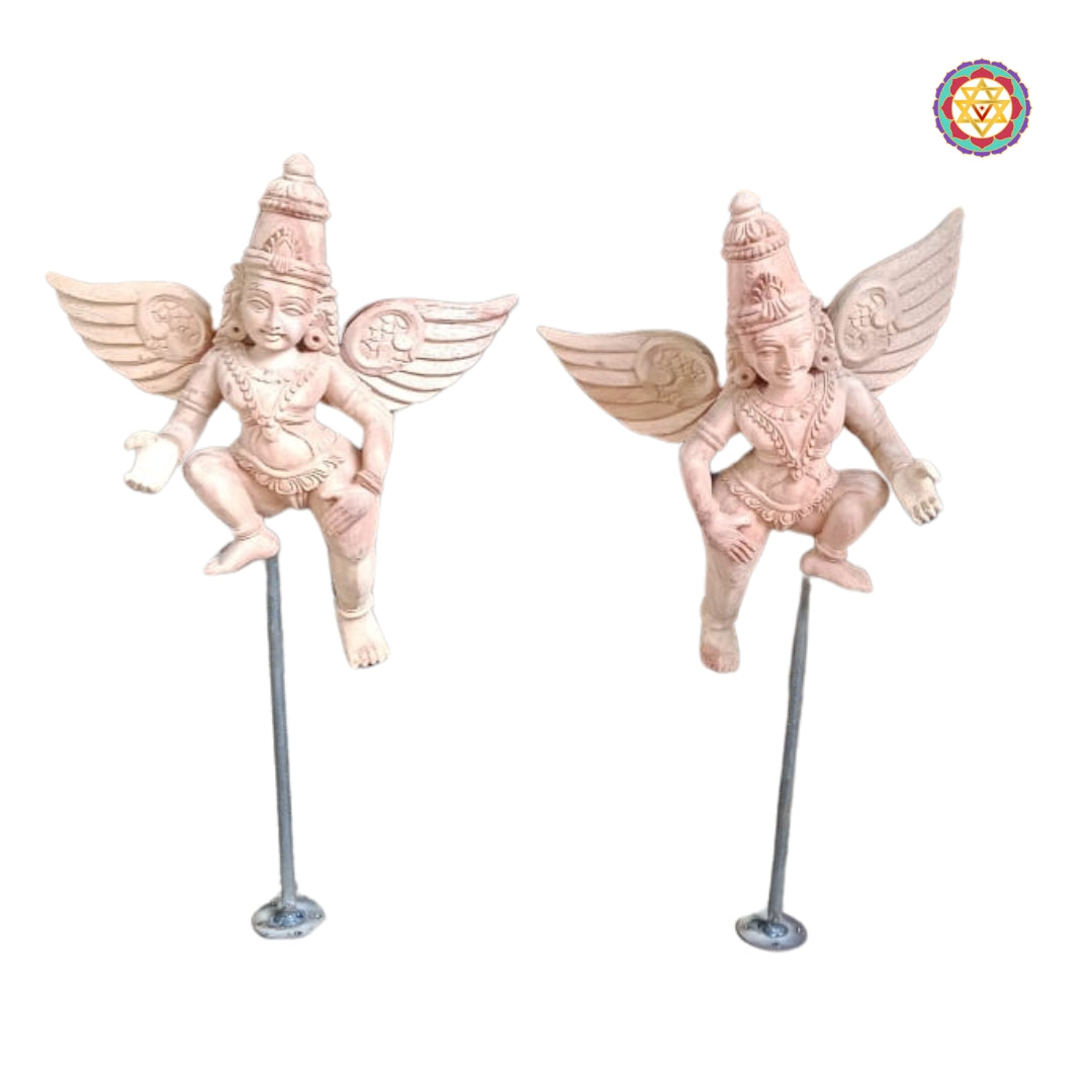Pair of primed hand-carved Gandharva figures in light-pink finish on metal rods — wall or tabletop mount mockup, artisan wood carving