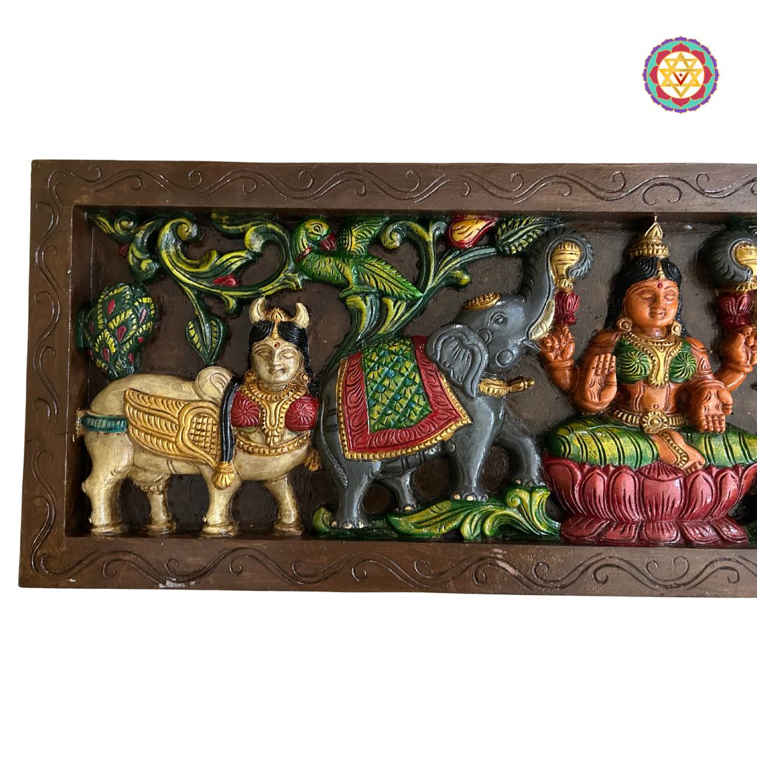 Angled view of Gajalakshmi wall hanging with floral carvings