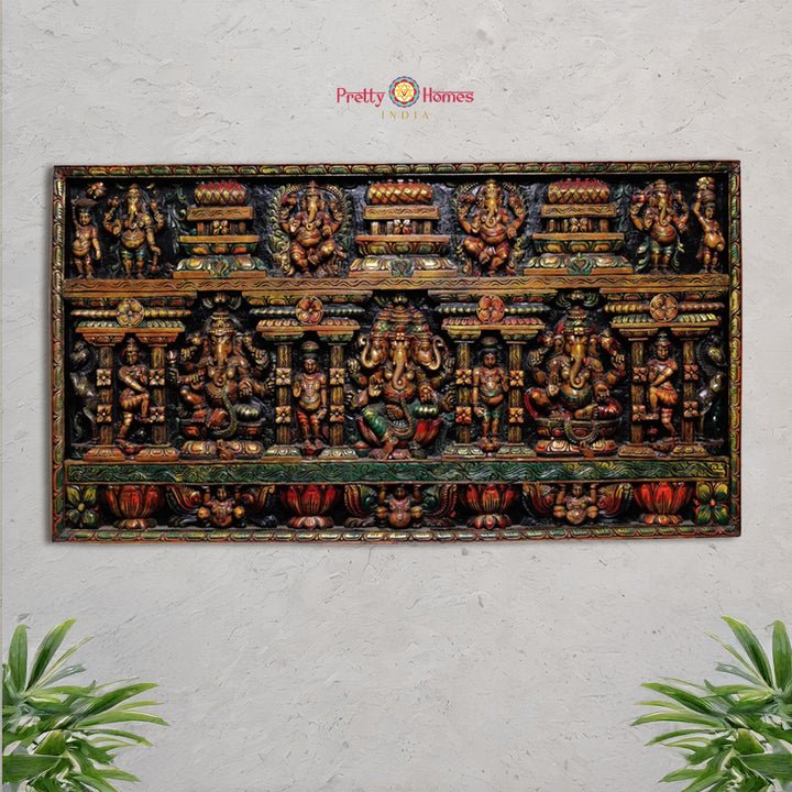 Close-up of three carved Ganesha figures in wooden wall panel