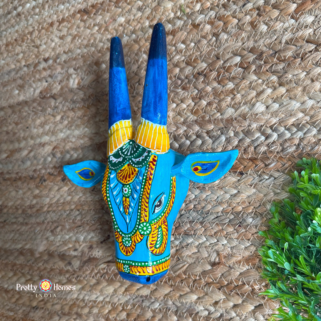Closeup of carved detailing on blue Nandi cow head wall decor