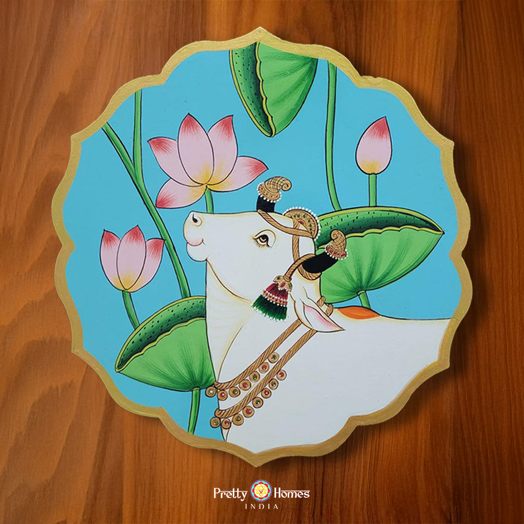 Blue petal-shaped pichwai cow wall plate with lotus flowers. Traditional lotus pichwai painting crafted for wall or table decor.