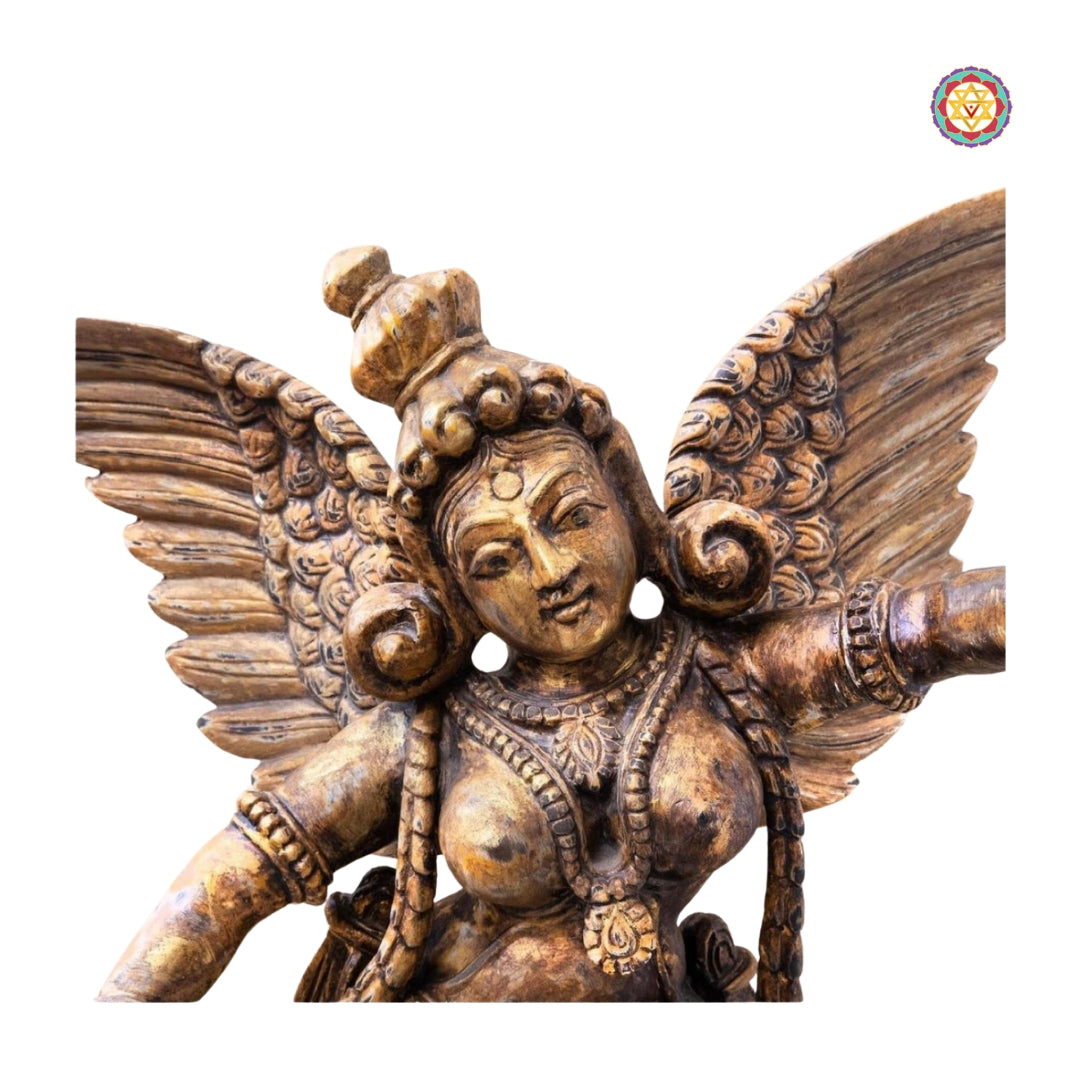 Angled view of Gandharva table top sculpture showing detailed wings and floral carvings on the base