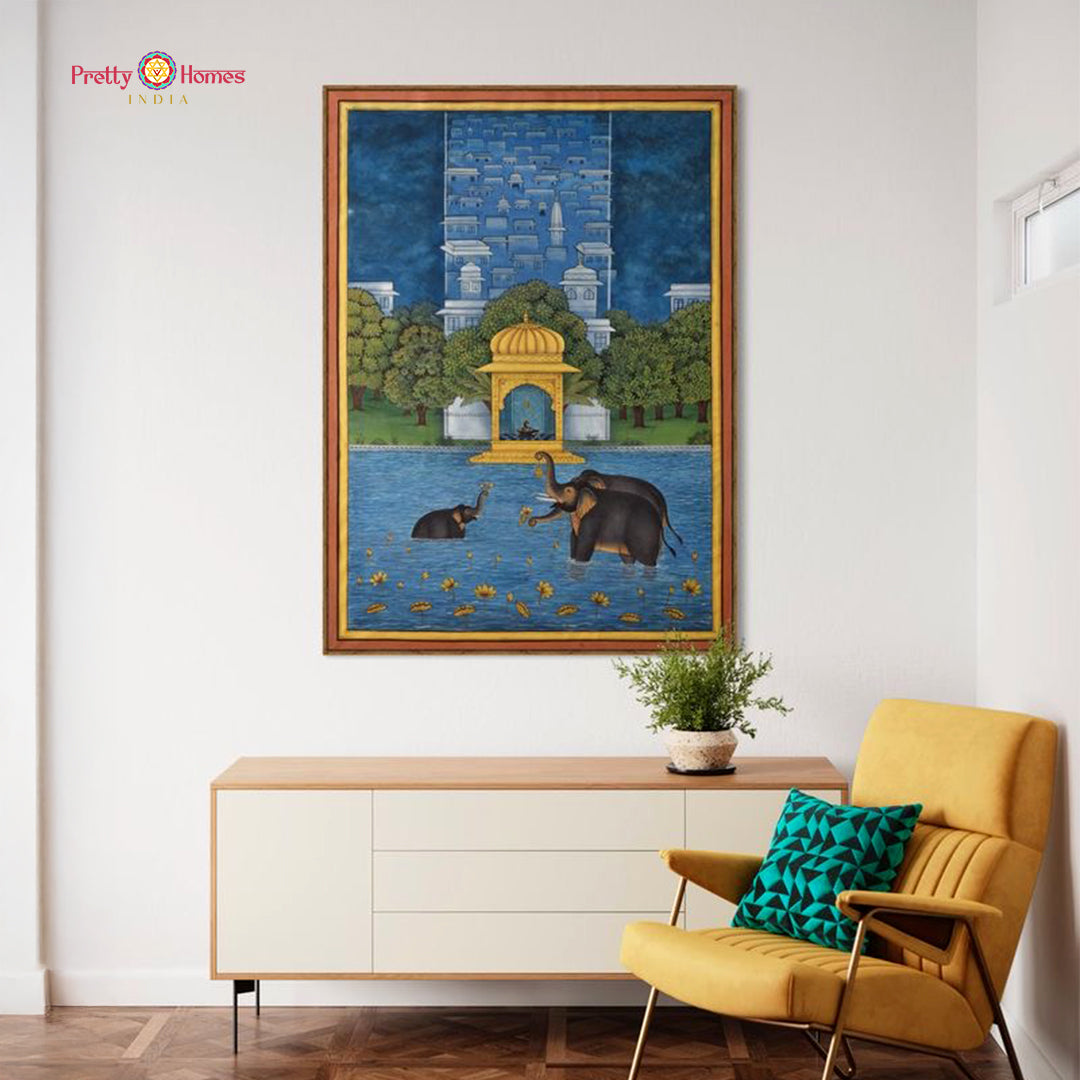 Framed pichwai style painting of elephants bathing in lotus pond with temple pavilion staged in living room